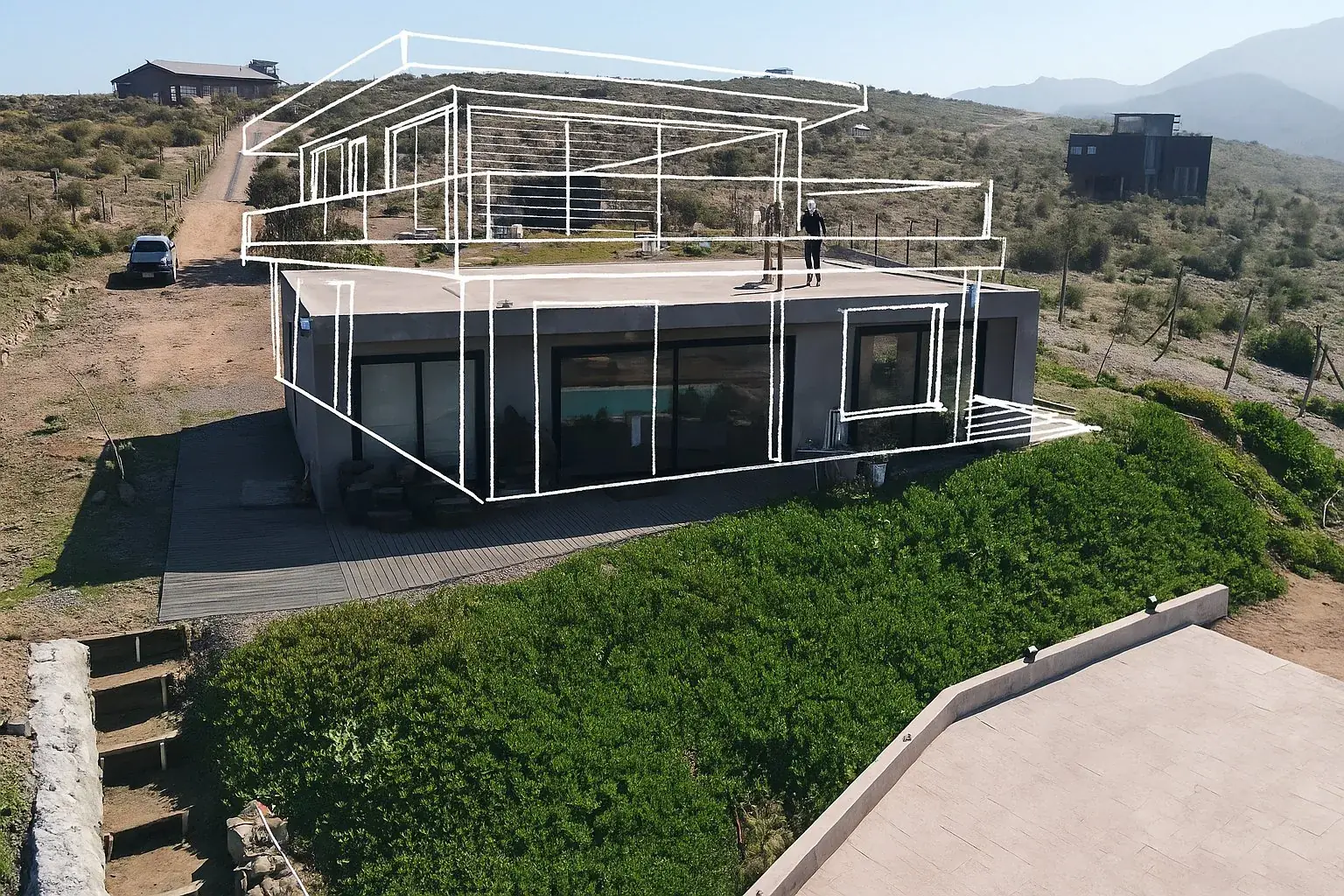 Vivienda de hormigón en la precordillera con el volumen del proyecto dibujado sobre la fotografía del terreno existente